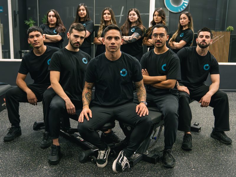 Diego Carquín al centro del equipo de ONE PERCENT en la sala de entrenamiento.