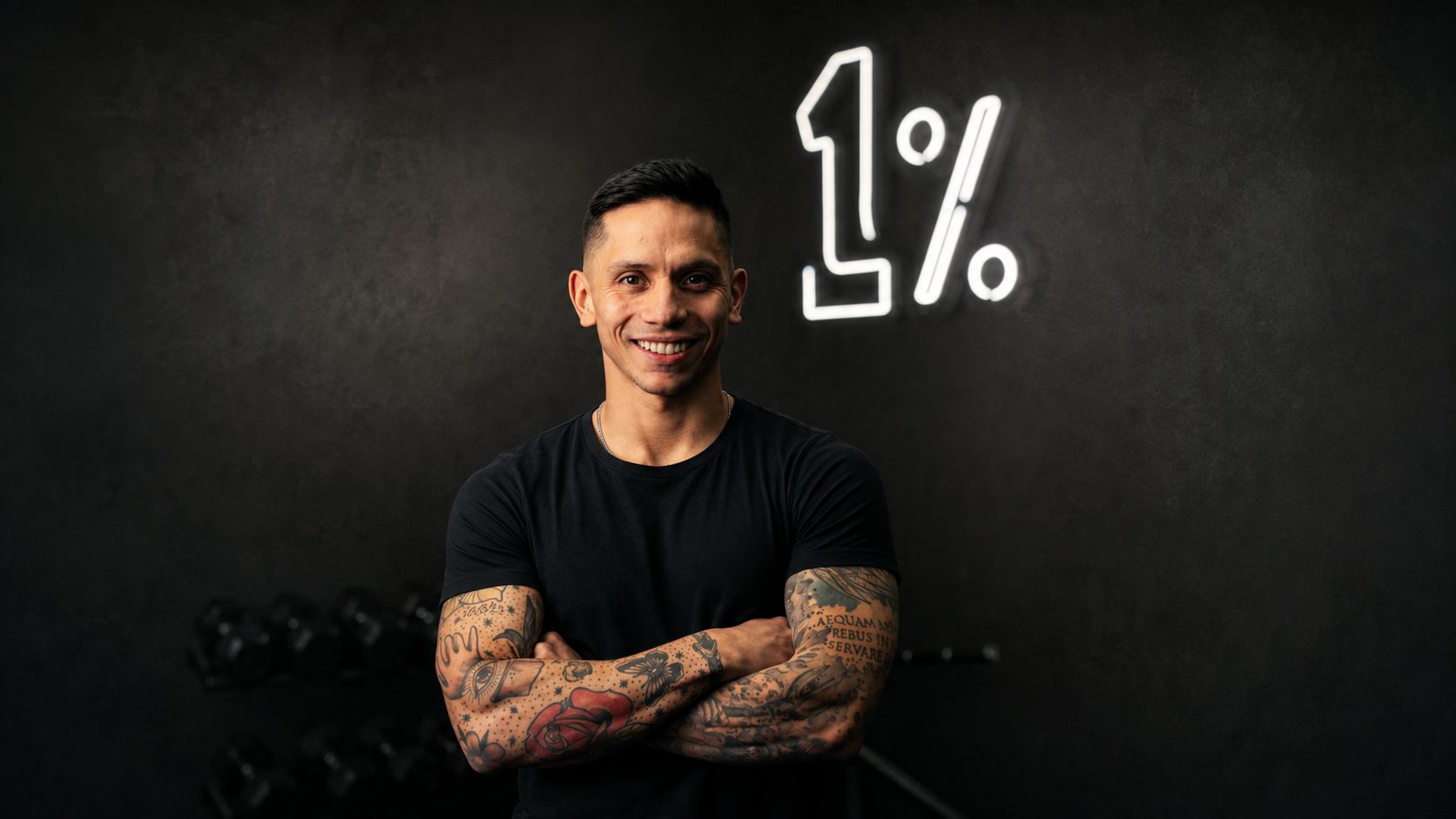 Diego Carquín de brazos cruzados frente al letrero de neón 1% en el centro ONE PERCENT.